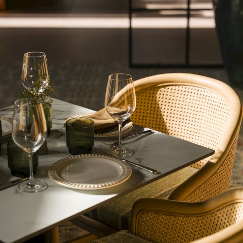 A cozy dining scene: a small round table set with plates and cutlery, two chairs, warm lighting, and a modern, intimate cafe vibe.